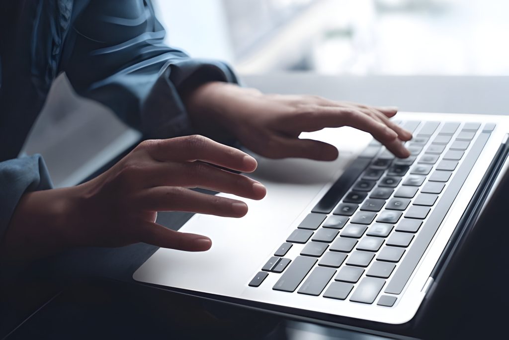 Business professional using a laptop in an office setting.